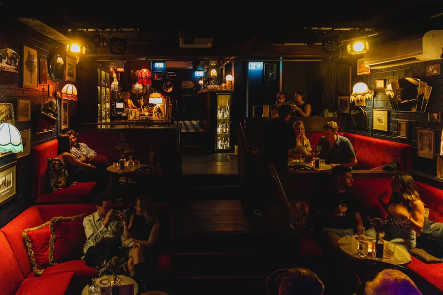 Red velvet booths and lamplight inside Dulcie’s Kings Cross